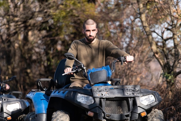 Hombre conduciendo campo a través con quad o atv