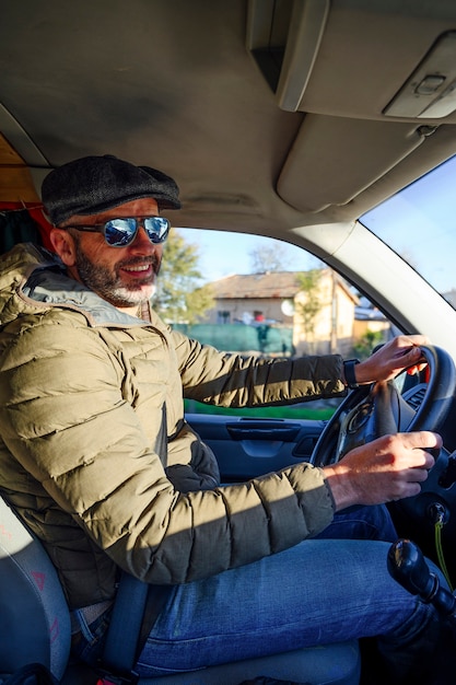 Hombre conduciendo un coche con gafas de sol