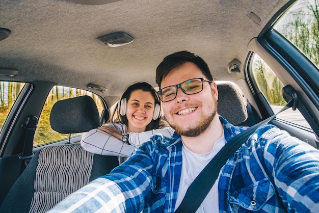 Hombre conduciendo coche mujer sentada como pasajero en los asientos traseros concepto de viaje en coche