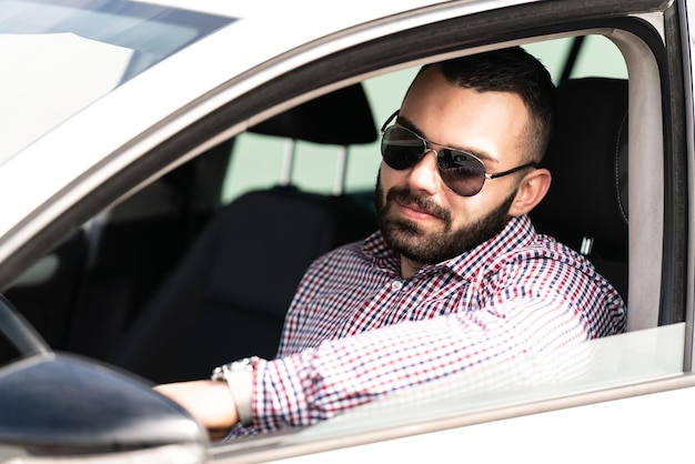 Foto hombre conduciendo un coche y sonriendo