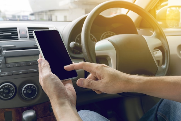 hombre conduciendo coche y usando teléfono móvil