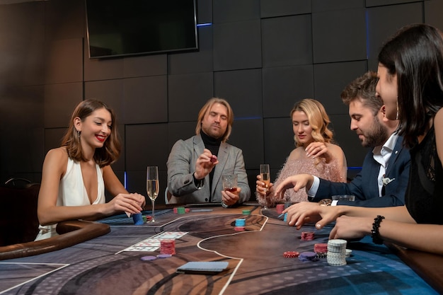 Hombre confiado haciendo apuestas mientras juega al póquer con amigos