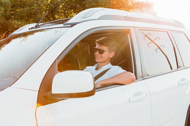 Hombre confiado hermoso joven que conduce el coche. viaje