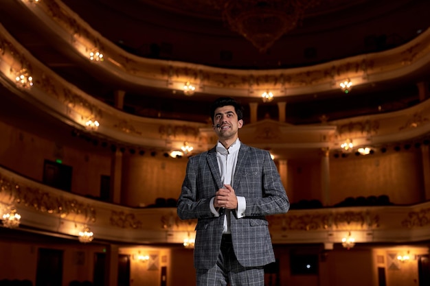 Hombre confiado en traje hablando dando entrenamiento de motivación desde la etapa de orador, hombre feliz de apariencia europea caucásica americana es exitoso y talentoso. gente, éxito, rendimiento