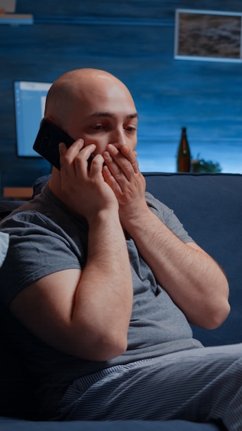 Foto hombre conmocionado, estresado, asombrado hablando por teléfono, recibiendo noticias horribles, sintiéndose traumatizado emocionalmente inestable, asustado, solo desesperado, vulnerable sufrimiento de enfermedad crónica