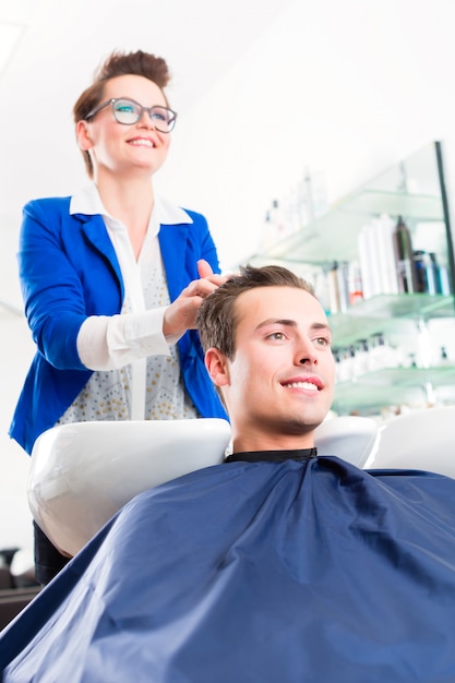 Hombre del consejo del peluquero en corte de pelo en barbería