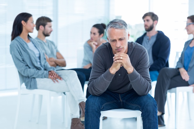 Hombre consolando a otro en el grupo de rehabilitación en la terapia