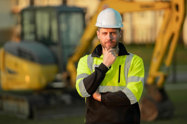 Hombre de la construcción con excavadora en sitio industrial trabajador en construcción de casco con bulldozer ingeniero wo