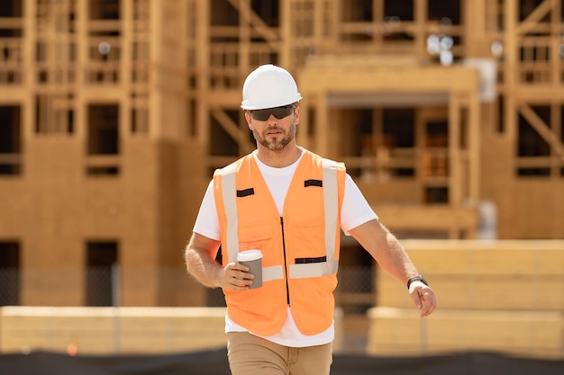Hombre de la construcción con trabajador de casco en construcción constructor de edificios nuevos en sitio de construcción forema