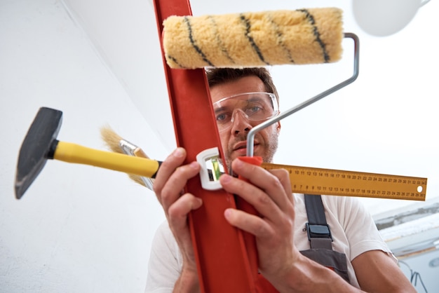Foto hombre constructor con herramientas de construcción. concepto de reparación