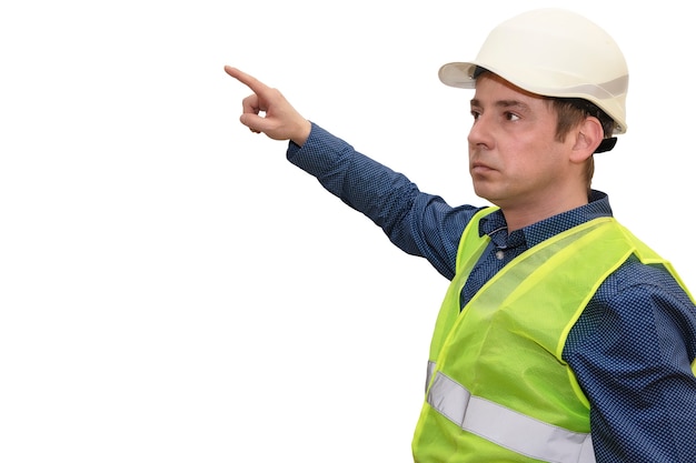 Hombre constructor o arquitecto en casco y chaleco de señales sobre un fondo blanco aislado puntos con un dedo.