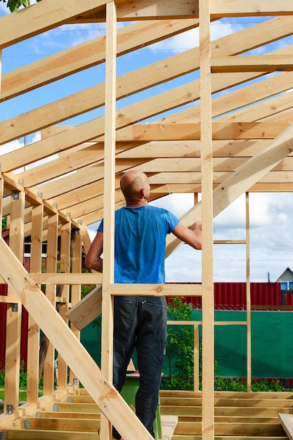 Un hombre construye una casa en el pueblo.