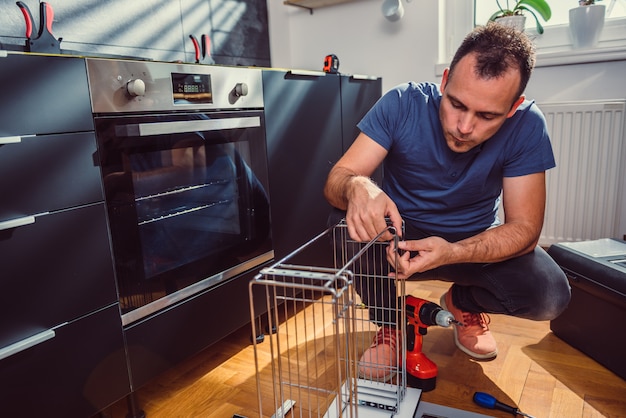 Foto hombre construyendo armarios de cocina