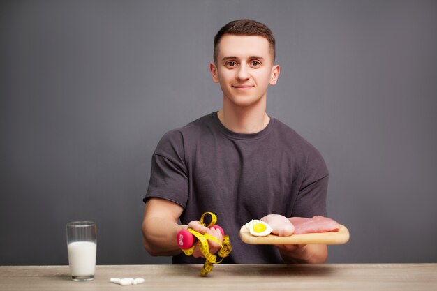 El hombre consume una comida rica en proteínas de carne y fruta.