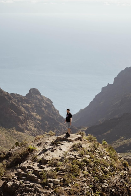 Hombre contemplando el horizonte en la cima de una montaña