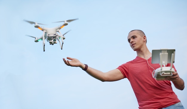 El hombre controla un quadrocopter en el parque