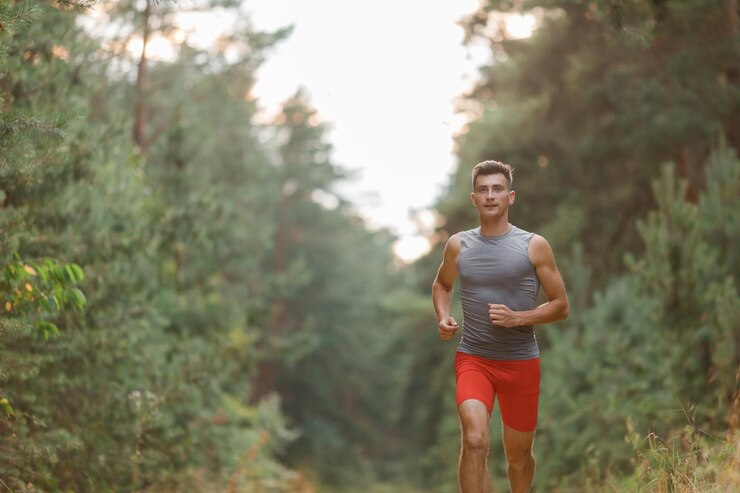 Hombre corriendo en el bosque matutino