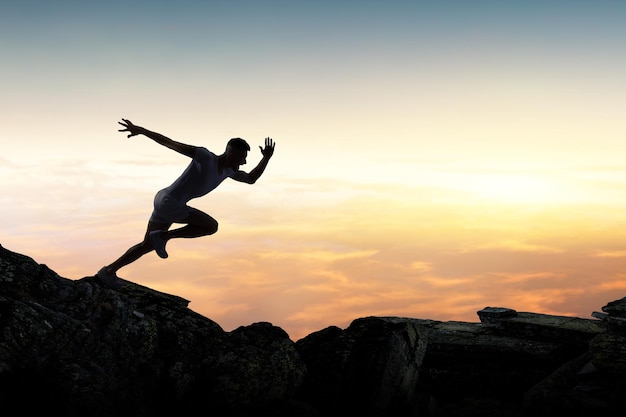 Hombre corriendo contra el fondo del cielo al atardecer