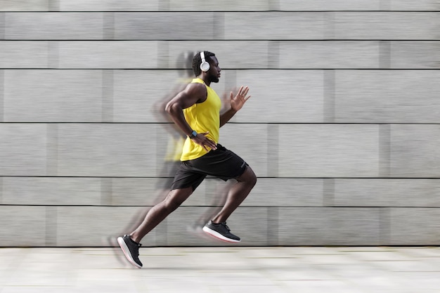 Hombre corriendo contra la pared gris