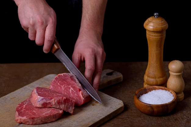 Hombre corta carne de res en tabla de cortar