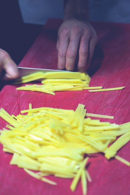 El hombre corta las papas para cocinar