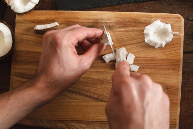 El hombre corta la pulpa de coco en el escritorio