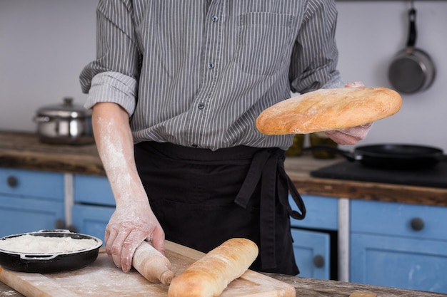 Hombre cortando pan en la cocina