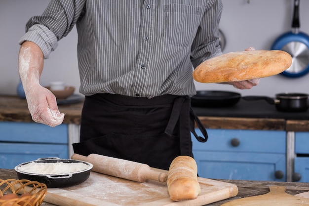 Hombre cortando pan en la cocina