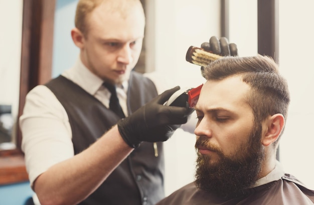 Hombre corte de pelo por estilista en peluquería. Cliente y peluquero con estilo