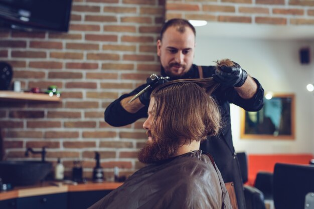 Hombre corte de pelo de moda en peluquería