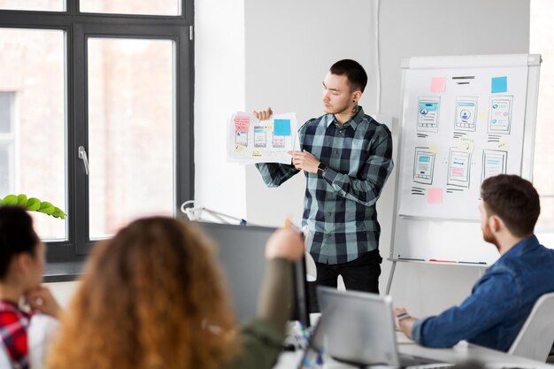 hombre creativo mostrando la interfaz de usuario en la oficina