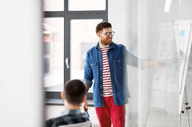 Foto hombre creativo mostrando la interfaz de usuario en la oficina