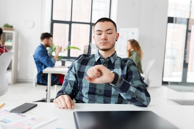 Foto hombre creativo con reloj inteligente trabajando en la oficina