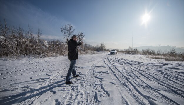 Hombre del crimen con pistola al aire libre en invierno