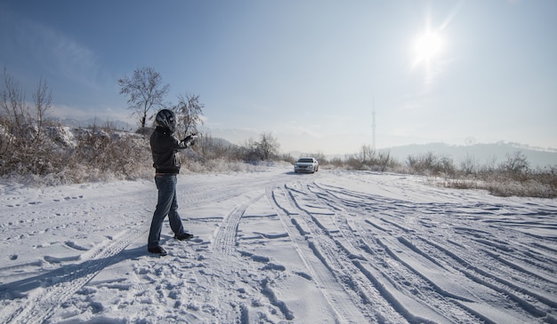 Hombre del crimen con pistola al aire libre en invierno