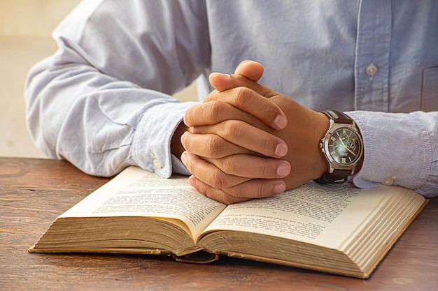 Hombre cristiano orando a Dios con la Biblia