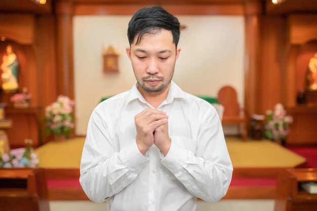 Hombre cristiano pidiendo bendiciones de DiosHombre asiático orando a Jesucristo