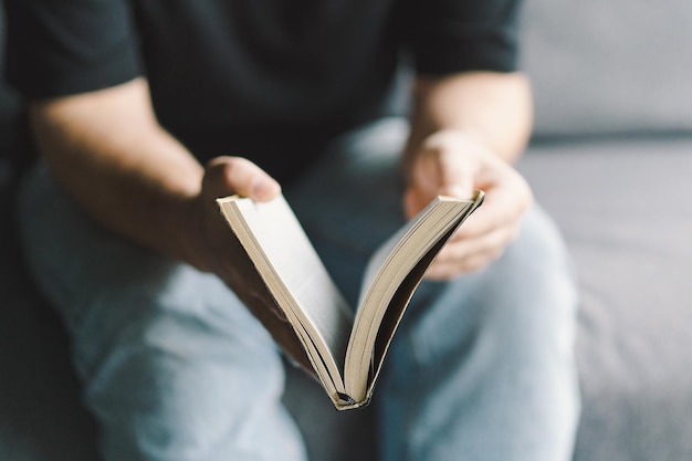 El hombre cristiano sostiene la Santa Biblia en las manos Leyendo la Santa Biblia en un hogar Concepto de fe espiritualidad y religión Esperanza de paz