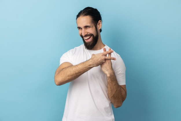 Hombre cruzando los dedos para hacer el signo del hashtag y mirando a la cámara con una sonrisa con dientes