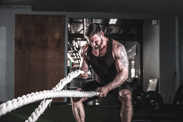 Hombre con cuerda en gimnasio de entrenamiento funcional