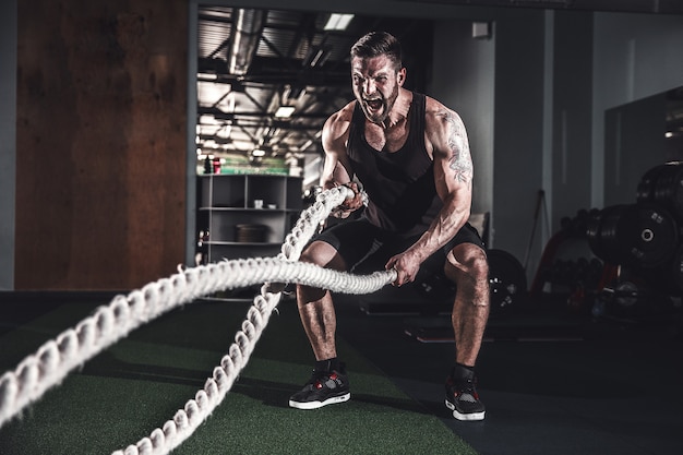 Hombre con cuerda en gimnasio de entrenamiento funcional