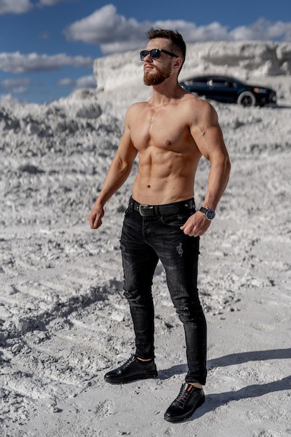 Hombre con cuerpo musculoso posando al aire libre sin camisa