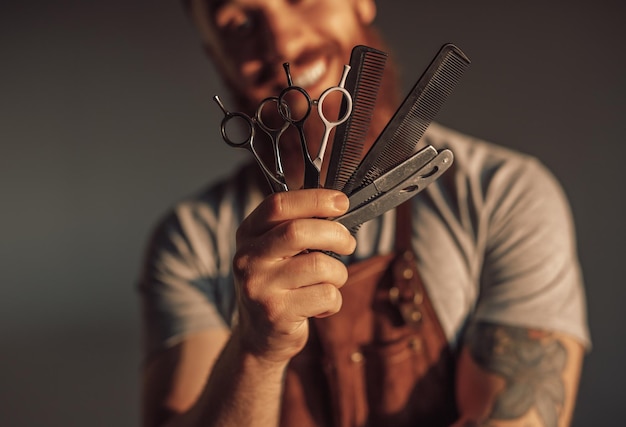 Hombre de cultivo mostrando herramientas de peluquero