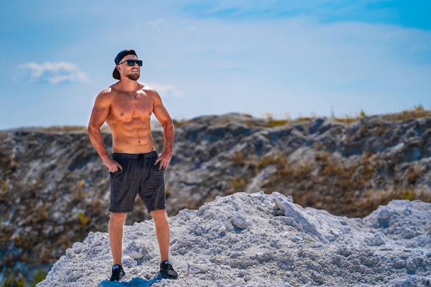 Hombre de culturismo sin camisa atleta. Hombre guapo musculoso al aire libre con el torso desnudo.