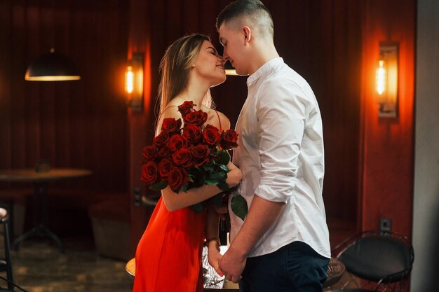 Foto el hombre da flores pareja romántica cena en el restaurante