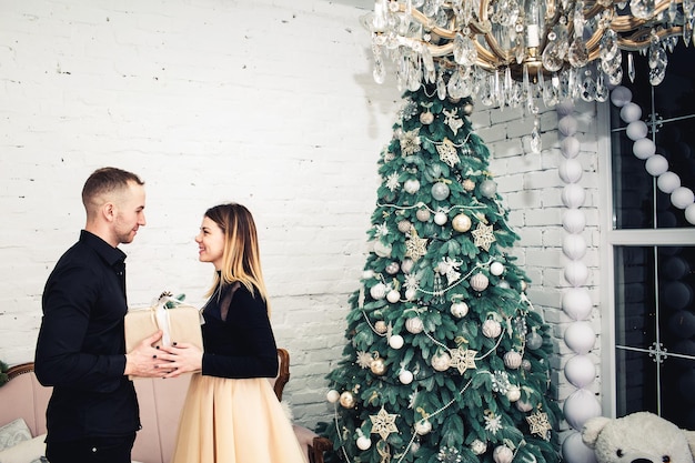 El hombre le da un regalo a la niña para Navidad