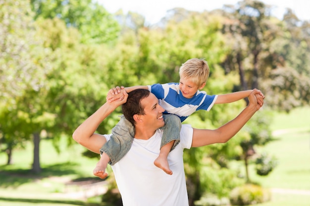 Foto hombre dando hijo a cuestas