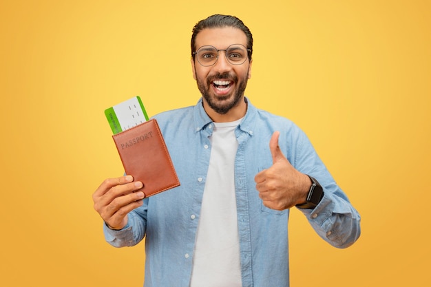 Hombre dando pulgares con pasaporte y boletos