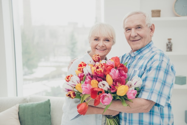 Hombre dando un ramo de flores a su esposa