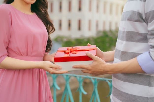 Hombre dando un regalo a su mujer. Pareja asiática, enamorado, aire libre